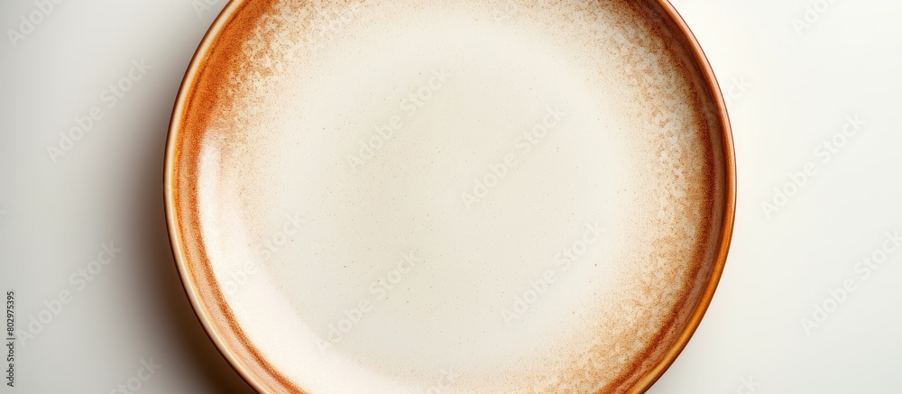 Poster A ceramic plate with a brown circle set on a white background is devoid of any objects with additional space for text or images