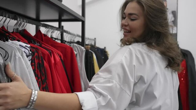 A fat woman chooses clothes to try on in a plus size store. 