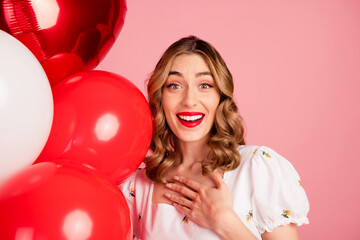 Photo portrait of lovely woman balloons amazed reaction dressed stylish white garment hairdo isolated on pink color background