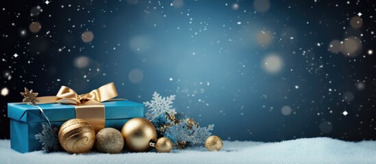 A festive Blue Christmas composition with a gift box sparkling gold snowflakes and ornament balls providing ample copy space for text