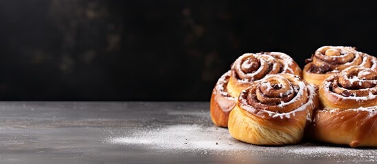 A copy space image of homemade cinnamon rolls a sweet and traditional dessert consisting of buns made from a homemade recipe served on a grey concrete table