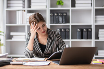 Young businesswoman has problems with her work in the office Feeling stressed and unhappy, showing...