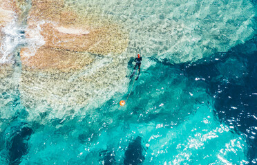 High angle view of man spearfishing in shallow water