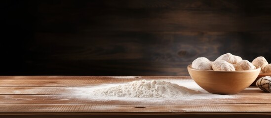 A copy space image of a wooden table with a bowl filled with fresh yeast dough creating a perfect spot for adding text