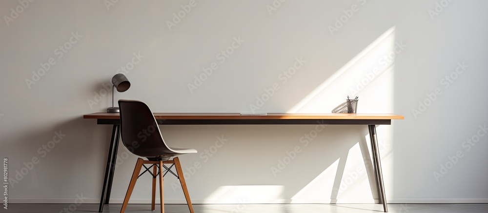 Poster A desk with ample free space and a white wall that casts shadows in the background creating an ideal copy space image