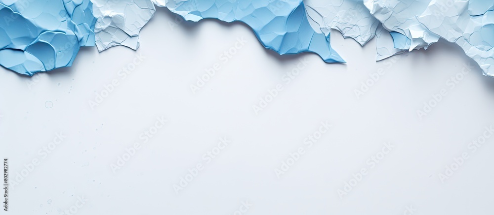 Poster A blue paper with torn edges is placed on a white paper background creating a copy space image