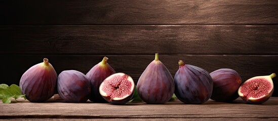 A copy space image of ripe fig fruits arranged on a rustic wooden table