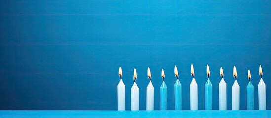 A blue background provides copy space for white and light blue birthday candles