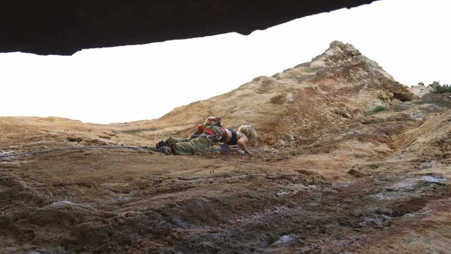 A woman is climbing a rocky hill