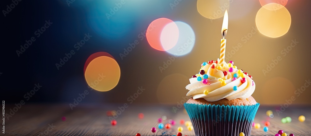 Aufkleber A birthday cupcake with a lit candle and colorful balloons serving as a blurred background providing space for text in the image. with copy space image. Place for adding text or design