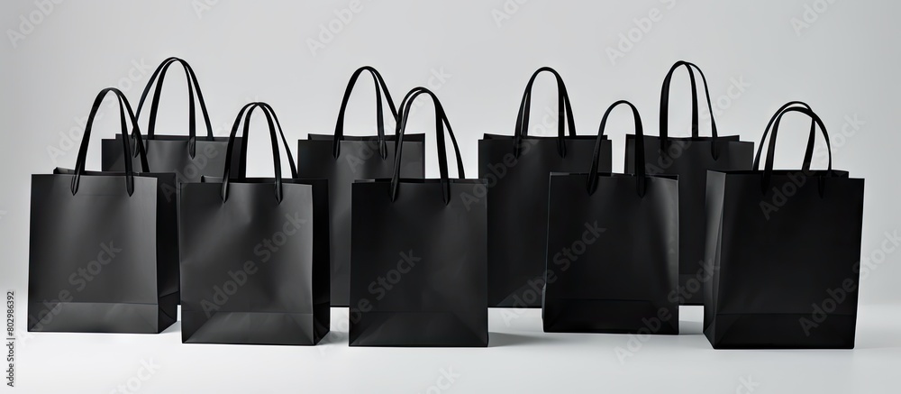 Poster a copy space image of a black shopping bag set against a white backdrop