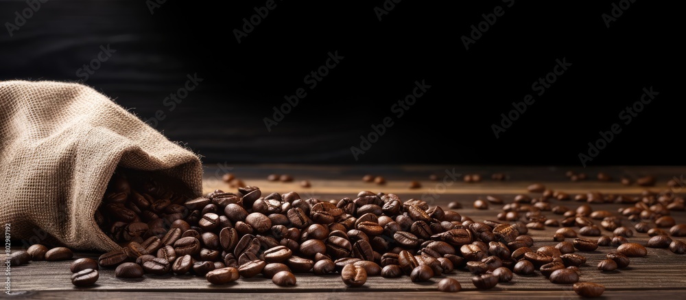 Aufkleber a copy space image of coffee beans spread on a wooden surface after being poured out of a bag