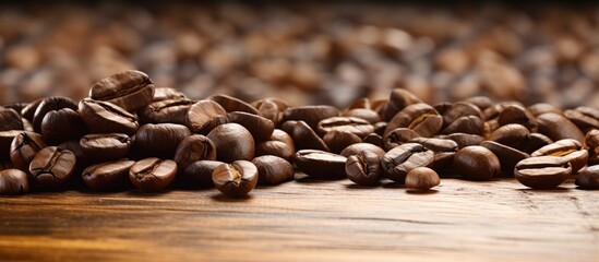 A close up copy space image showing raw coffee beans on a wooden table top ready to be transformed into a delicious beverage