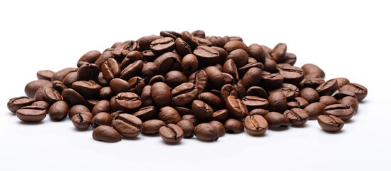 A close up copy space image of roasted coffee beans against a white background