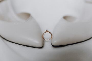 A ring is placed on a pair of white shoes