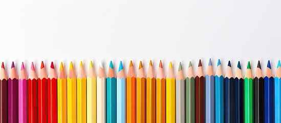 A copy space image showcasing colorful pencils placed on a white backdrop