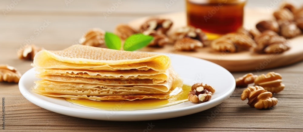 Poster a copy space image of crepes honey and nuts on a white plate placed on a wooden background
