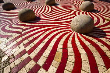 AI generated illustration of vibrant red and white patterned floor with round rocks