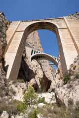 Low angle shot from the bottom of the gorge of the historic Mascarat bridges in Alicante, between the towns of Calpe and Altea, Spain