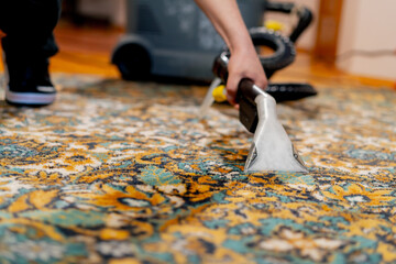 close up professional cleaning of the apartment the a cleaner washes and vacuums the carpet from...