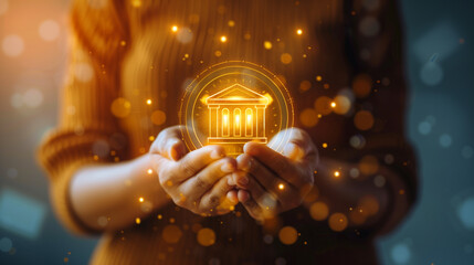 Woman holding glowing bank icon in her hands. Financial and banking concept