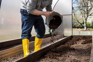 The farmer pourvu new soil, soil for a new greenhouse. The concept of spring planting of vegetables...
