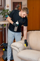 professional cleaning in an apartment cleaner applies a polishing agent to a leather sofa