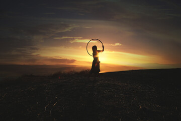 woman with hula hoop on the sunset