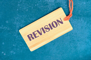 Business concept. REVISION word on the card on an abstract background