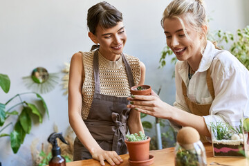 Two women admiring a potted plant with love and curiosity.