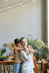 Two women in the room, sharing a warm and loving embrace.
