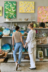 Loving, artistic lesbian couple standing together in cozy art studio.