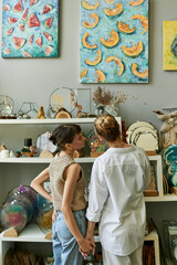 Two women in an art studio, sharing a tender moment.