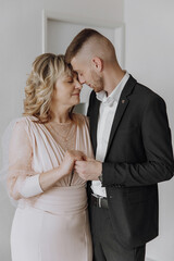 A man and a woman are hugging each other. the groom with his mother