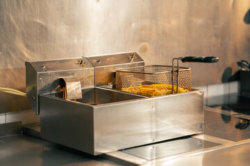 close-up in professional kitchen there are ready-made French fries on the deep fryer