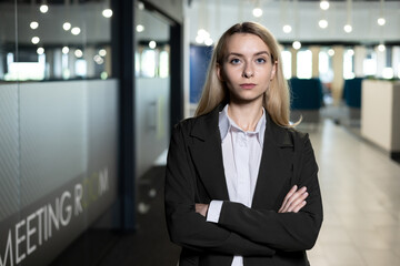 Confident businesswoman standing in office corridor
