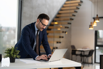 Obraz premium Handsome businessman in suit working at office 