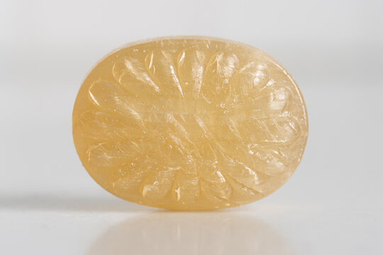 lemon flavor candy on white background, close up macro shot of hard candy, oval with texture, copy space
