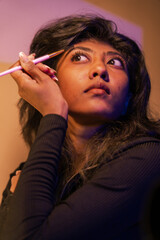 Obraz premium A woman is applying makeup with a brush