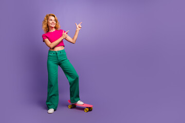 Photo of adorable cheerful pretty woman wear stylish clothes showing empty space isolated on purple color background