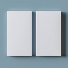 Two blank white books against a grey background