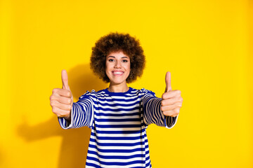Portrait of pretty young woman show thumb up wear striped shirt isolated on yellow color background