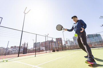 woman playing paddle tennis outdoors.