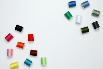 Multicolored sewing threads on white background. Top view, copy space