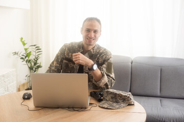 Portrait of young army soldier with a laptop 