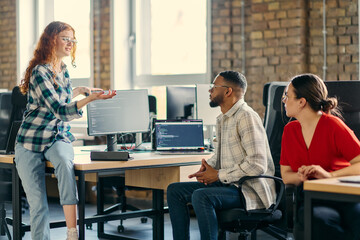 Fototapeta premium A diverse group of young business individuals congregates in a modern startup coworking center, embodying collaborative innovation and a dynamic atmosphere