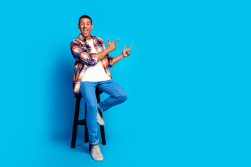 Full size photo of nice young man direct fingers empty space wear shirt isolated on blue color background