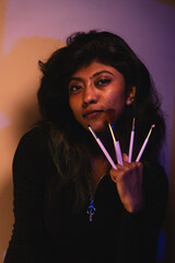 Obraz premium A woman is holding four makeup brushes in her hand