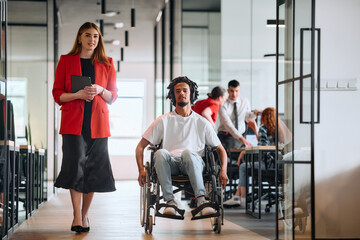 A business leader with her colleague, an African-American businessman who is a disabled person,...