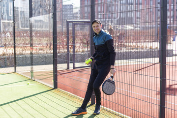 Paddle tennis player serving training with her couple in court